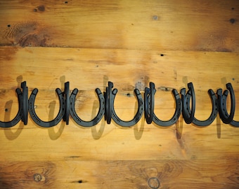 6 Coat Wall mounted authentic horseshoe coat racks. 32 5/8L x 4 1/2W x 4 3/4H.