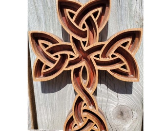 May include: A wooden Celtic knot cross with intricate details. The cross is made of light and dark wood, creating a beautiful contrast. The knot design is a traditional symbol of eternity and interconnectedness.