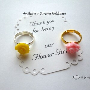 May include: Two flower girl rings with a yellow rose and a pink rose. The rings are available in silver or gold. The card reads "Thank you for being our Flower Girl".