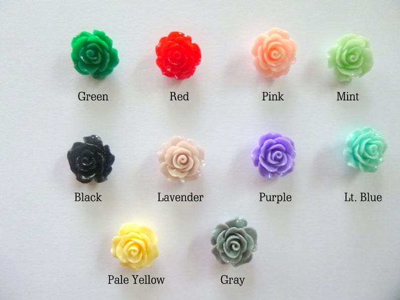 Op de afbeelding: Assortiment van tien kleine plastic roosvormige versieringen in verschillende kleuren, waaronder groen, rood, roze, mint, zwart, lavendel, paars, lichtblauw, lichtgeel en grijs.
