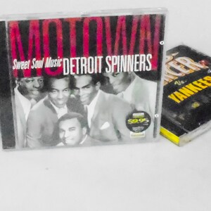 May include: Three compact discs, one with a black and white photo of a group of men and the text "Motown Sweet Soul Music Detroit Spinners", one with a black and white photo of a group of people and the text "Motown", and one with a black and white photo of a group of people and the text "The Yankees".