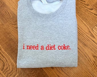 Bluza z haftem „Potrzebuję Coca-Coli Light” | Zabawna bluza z haftem | Szary okrągły dekolt | Przytulny, graficzny sweter | Prezent dla miłośników Coca-Coli Light
