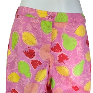 K&ouml;nnte beinhalten: Rosa Baumwollshorts mit einem Zitronen- und Erdbeerprint. Die Shorts haben einen Knopfverschluss und einen rosa Bund.
