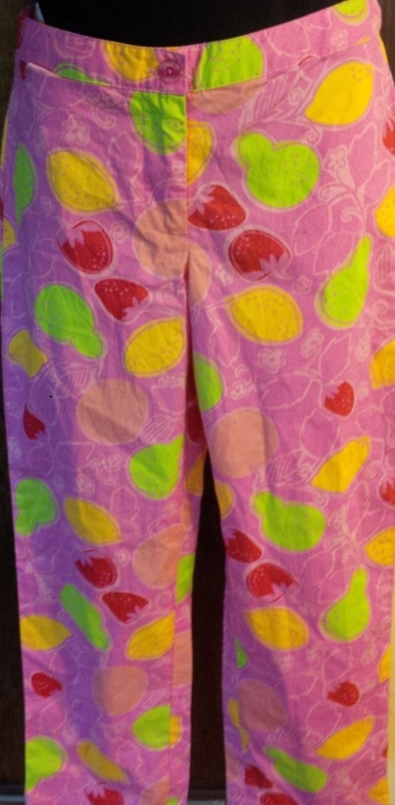 K&ouml;nnte beinhalten: Rosa Hose mit einem bunten Fr&uuml;chte-Druck. Der Druck zeigt Zitronen, Limetten und Erdbeeren.