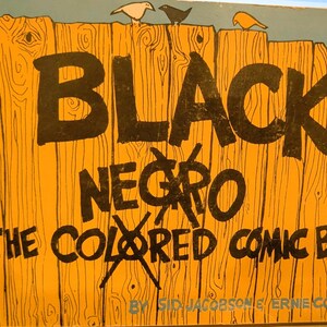 Puede incluir: Una portada de c&oacute;mic vintage con el t&iacute;tulo "BLACK NEGRO THE COLORED COMIC BOOK" en letras negras en negrita. El fondo es un dise&ntilde;o de valla de madera con tres ilustraciones de p&aacute;jaros en la parte superior. La portada es naranja y azul.