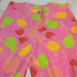 K&ouml;nnte beinhalten: Rosa Baumwollshorts mit einem Zitronen- und Erdbeerprint. Die Shorts haben einen Bund mit Knopf- und Rei&szlig;verschluss.