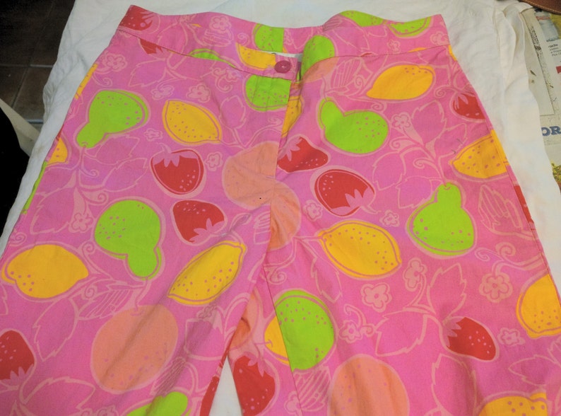 K&ouml;nnte beinhalten: Rosa Baumwollshorts mit einem Zitronen- und Erdbeerprint. Die Shorts haben einen Bund mit Knopf- und Rei&szlig;verschluss.