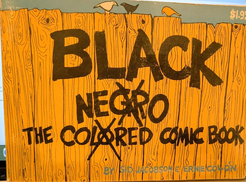 Puede incluir: Una portada de c&oacute;mic vintage con el t&iacute;tulo "BLACK NEGRO THE COLORED COMIC BOOK" en letras negras en negrita. El fondo es un dise&ntilde;o de valla de madera con tres ilustraciones de p&aacute;jaros en la parte superior. La portada es naranja y azul.