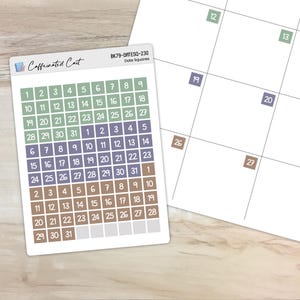 Può includere: Un foglio di adesivi con una griglia di calendario con i numeri da 1 a 31. Gli adesivi sono in tonalità di verde, marrone e viola. Gli adesivi sono etichettati "BK79-DATESQ-230 Date Squares".