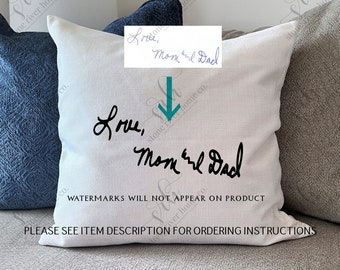 May include: White pillow with the text "Love, Mom and Dad" written in black cursive. The text "WATERMARKS WILL NOT APPEAR ON PRODUCT" is printed in black below the cursive text. The pillow is sitting on a couch with a blue pillow behind it.