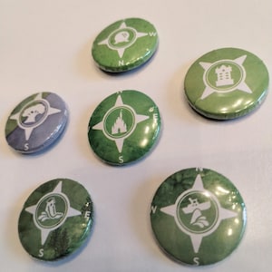 May include: Six green and white compass-shaped buttons with different icons. The icons include a castle, a tree, a boat, a castle, a tree, and a building.