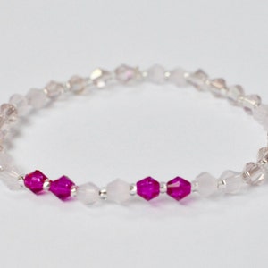 Peut inclure: Un bracelet délicat composé de perles de cristal claires et roses. Le bracelet présente un dégradé de perles roses au centre.