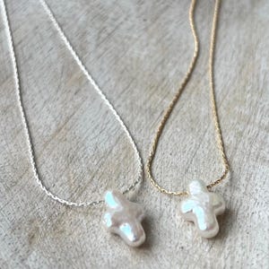 Collar con cruz de perlas de agua dulce: Cadena chapada en oro o plata de ley.