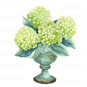 May include: A bouquet of green hydrangeas with white centers arranged in a blue and green ceramic vase with a distressed finish.
