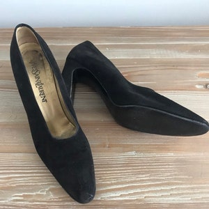 Peut inclure: Une paire de talons hauts en daim noir &agrave; bout pointu. Les talons mesurent environ 7,5 cm de haut et les chaussures sont &eacute;tiquet&eacute;es "Yves Saint Laurent".