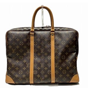 May include: A brown and tan leather briefcase with a monogram pattern. The briefcase has a top handle and a zipper closure.