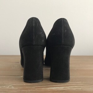 Peut inclure: Une paire de chaussures &agrave; talons en daim noir avec un talon bloc.