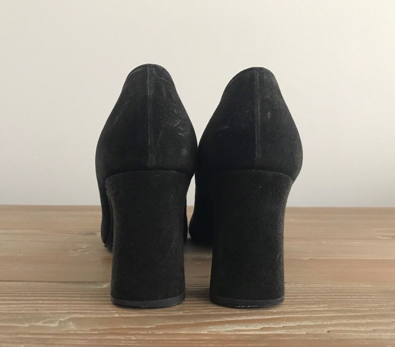 Peut inclure: Une paire de chaussures &agrave; talons en daim noir avec un talon bloc.