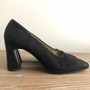 Peut inclure: Pumps en daim noir avec un talon bloc &eacute;pais.