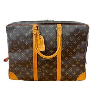 May include: A brown and tan leather Louis Vuitton briefcase with a monogram pattern. The briefcase has a top handle and a zipper closure.
