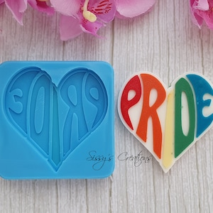 May include: A silicone mold for making a heart-shaped cake or cookie decorated with the word "PRIDE" in rainbow colors.