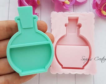 Puede incluir: Un molde de silicona verde para hacer dijes de botella de resina. El molde tiene la forma de una botella redonda con un tapón y un estante en el interior. El molde se sostiene en una mano, y un molde de silicona rosa es visible en el fondo.