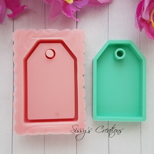 Puede incluir: Dos moldes de silicona para hacer manualidades de resina. El molde de la izquierda es rosa y tiene un borde festoneado. El molde de la derecha es verde y tiene un borde liso. Ambos moldes tienen forma de etiqueta con un agujero en la parte superior.