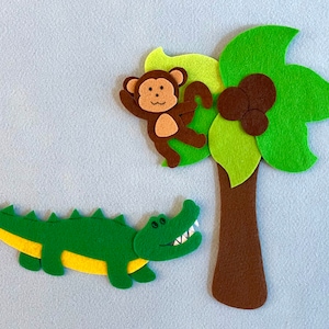 May include: A felt applique set featuring a green alligator, a brown monkey, and a green palm tree with brown coconuts. The set is perfect for a child's playroom or bedroom.