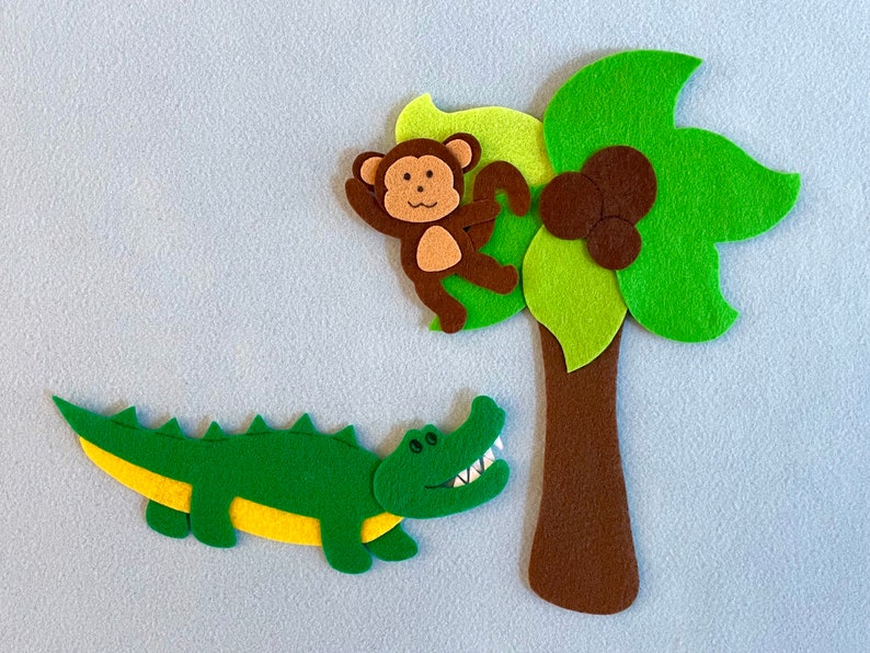 May include: A felt applique set featuring a green alligator, a brown monkey, and a green palm tree with brown coconuts. The set is perfect for a child's playroom or bedroom.