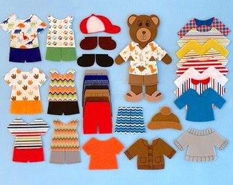 May include: Felt toy clothing pieces for a bear or doll. The set includes a variety of shirts, pants, shorts, hats, and shoes in different colors and patterns.