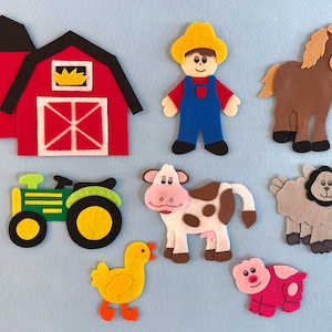 May include: Felt farm animal set with a red barn, a green tractor, a brown horse, a white and brown cow, a gray sheep, a pink pig, a yellow chick, and a farmer wearing blue overalls.