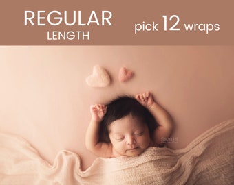 May include: A newborn baby is swaddled in a cream-colored fabric wrap and lying on a light pink background. The baby's arms are raised above their head. Two small pink felt hearts are on the background above the baby.
