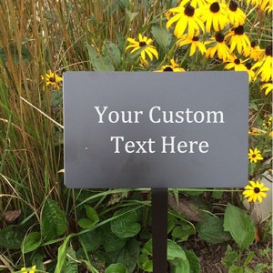 Black metal yard plaque with stake. Engraved with your custom text. Black metal with white text. Custom sizes are available 8x5 inch with 25 inch stake included for easy installation.