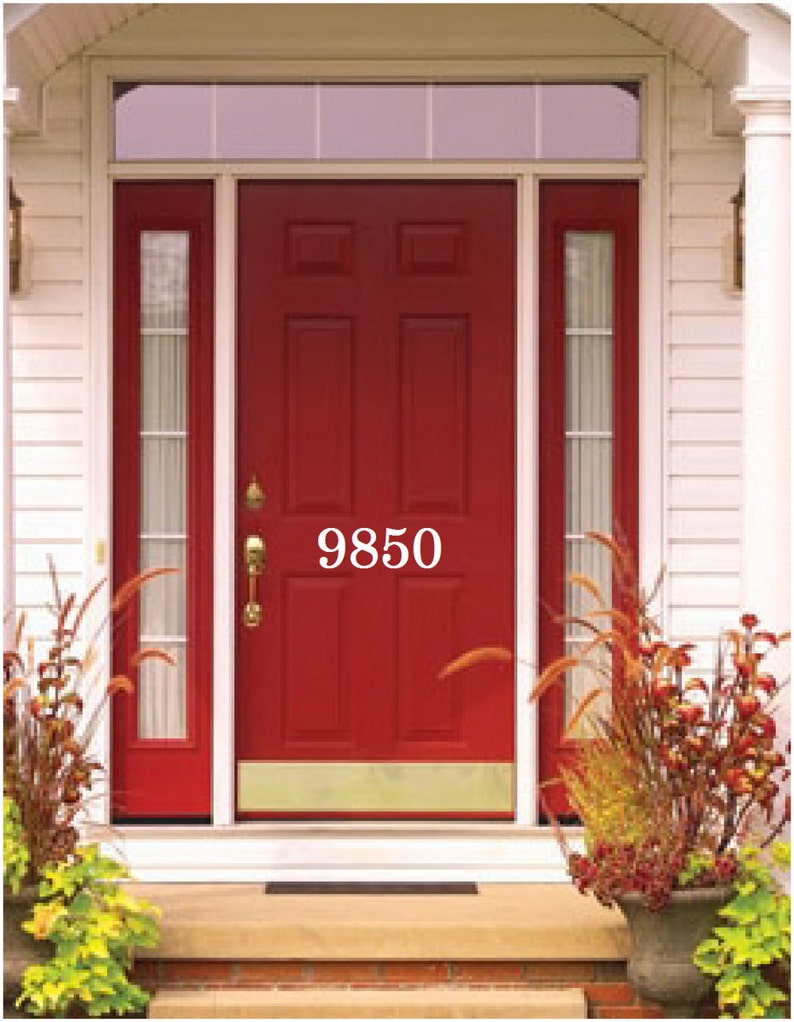 Pode incluir: Uma porta de entrada vermelha com uma placa de porta de lat&atilde;o e um n&uacute;mero de casa branco "9850" na porta. A porta tem uma janela de vidro de cada lado e uma pequena janela de vidro acima da porta.
