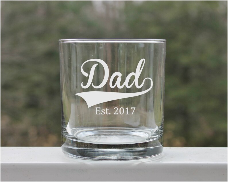 Etched Dad whiskey glass is the perfect addition to any barware collection. 11oz capacity, it is versatile enough to be used for any cocktail.  Etched with dad and est year.