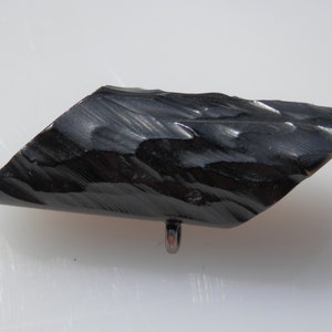 Peut inclure: Un pendentif en obsidienne noire avec une surface lisse et polie et une boucle argentée pour l'accrocher.