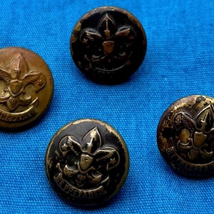 Könnte beinhalten: Vier vintage Boy Scout Knöpfe mit dem Boy Scout Emblem und den Worten "Be Prepared". Die Knöpfe sind gold und schwarz mit einem erhabenen Design.