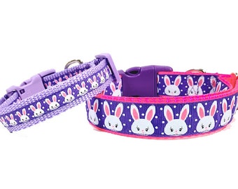 May include: Two purple dog collars with white bunny faces and pink polka dots. The smaller collar is a lighter shade of purple.