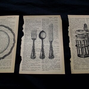 May include: Three vintage dictionary pages featuring black ink illustrations. The left page shows a scalloped plate, the center page displays a fork, spoon, and knife, and the right page depicts a pair of glass salt and pepper shakers in a metal holder.