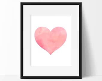 May include: A framed print of a pink watercolor heart on a white background.