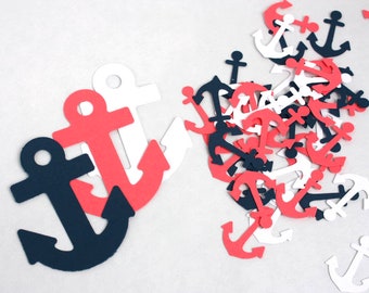 May include: A collection of paper anchor cutouts in red, white, and blue. The anchors are scattered on a white surface.