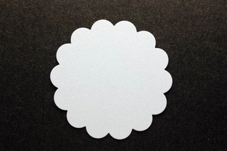 Pu&ograve; includere: Un cerchio bianco a forma di conchiglia su uno sfondo nero.