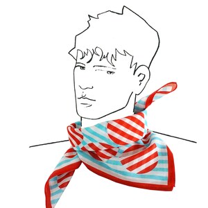 Puede incluir: Un pañuelo de rayas rojas y azules con lunares blancos. El pañuelo está atado alrededor del cuello de una persona.