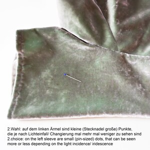 May include: A close-up of a light green velvet fabric with small pin-sized dots. The dots are visible depending on the light incidence or iridescence. 2.Wahl: auf dem linken &Auml;rmel sind kleine (Stecknadel gro&szlig;e) Punkte, die je nach Lichteinfall/ Changierung mal mehr mal weniger zu sehen sind 2.choice: on the left sleeve are small (pin-sized) dots, that can be seen more or less depending on the light incidence/ iridescence