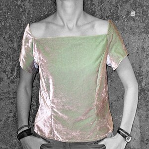 May include: A light green velvet top with a square neckline and short sleeves. The top is fitted and has a slightly cropped length.