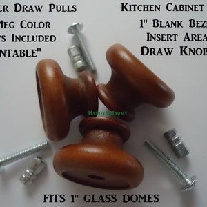 May include: Three wooden drawer pulls in a nutmeg color. The pulls are 1 inch in diameter and have a blank bezel insert area. The pulls come with screws and are paintable. The text "DRESSER DRAW PULLS", "NUTMEG COLOR", "SCREWS INCLUDED", "PAINTABLE", "KITCHEN CABINET PULLS", "1" BLANK BEZEL", "INSERT AREA", "DRAW KNOBS", "FITS 1" GLASS DOMES" is visible in the image.
