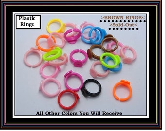 May include: Assortment of colorful plastic rings. The rings are all the same size and shape, but they come in a variety of colors, including pink, red, orange, yellow, green, blue, and purple. The rings are sold out in brown.