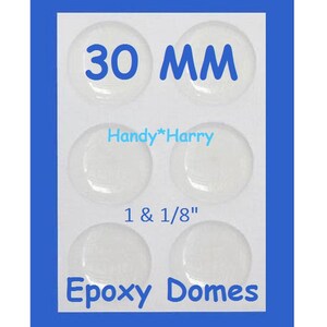 May include: A sheet of six clear epoxy domes, each approximately 1 1/8 inches in diameter, with the text "30 MM" and "Epoxy Domes" in blue. The brand name "Handy*Harry" is also visible.