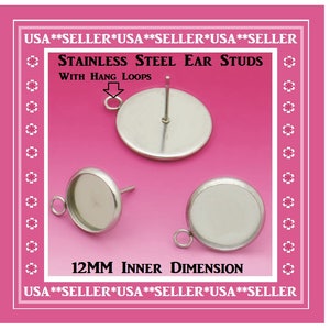 May include: Two silver stainless steel ear studs with a 12mm inner dimension. Each stud has a round, flat base with a small loop on the side and a post for inserting an earring back. The text "USA**SELLER*USA**SELLER*USA**SELLER" appears at the top and bottom of the image. The text "STAINLESS STEEL EAR STUDS" and "WITH HANG LOOPS" appears in the center of the image.