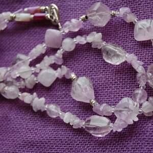 May include: A multi-strand necklace made of light purple amethyst beads of various shapes and sizes. The necklace is made of both smooth and faceted beads, and is accented with silver beads.